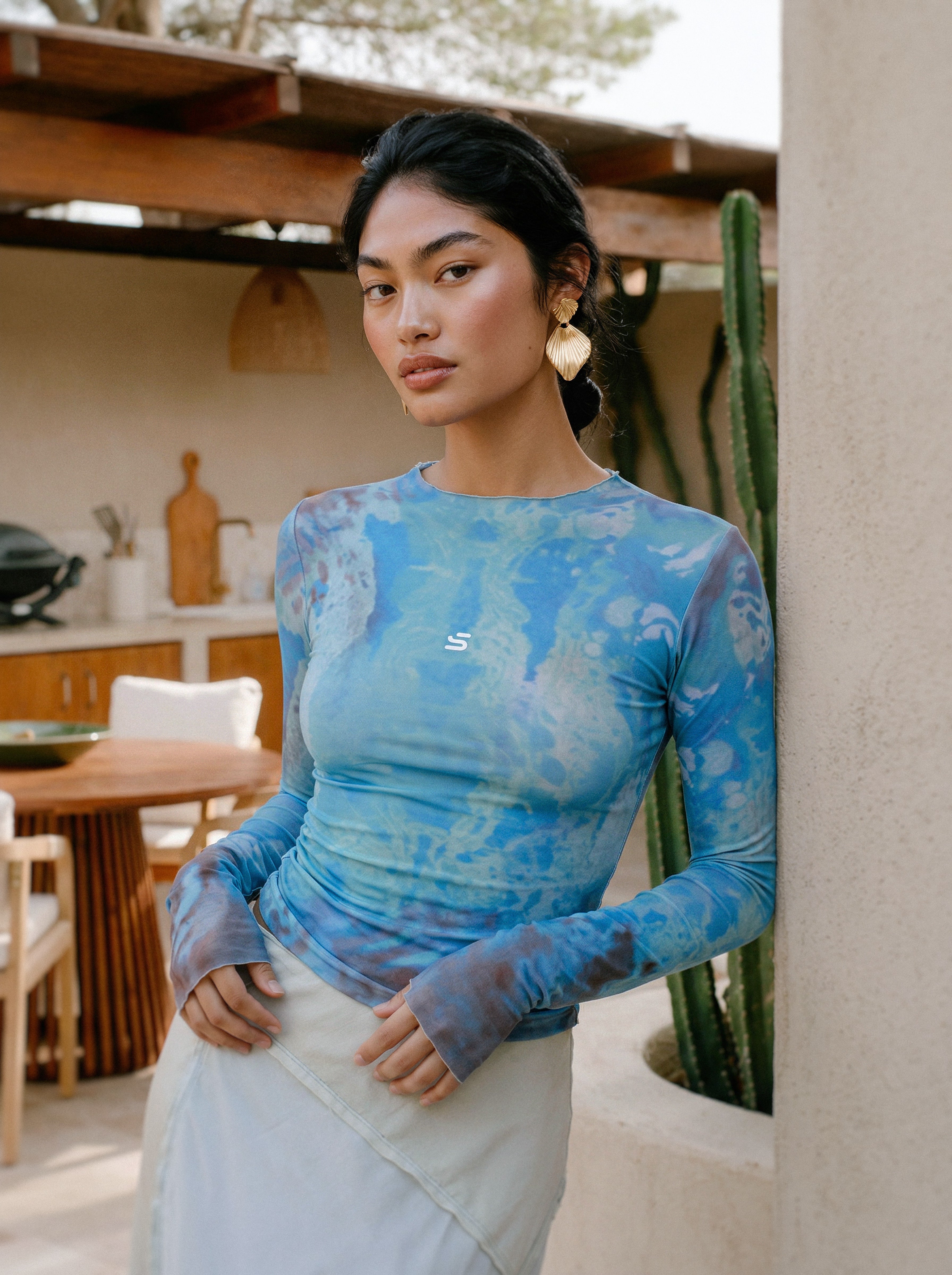 Woman wearing a blue patterned top in an outdoor setting