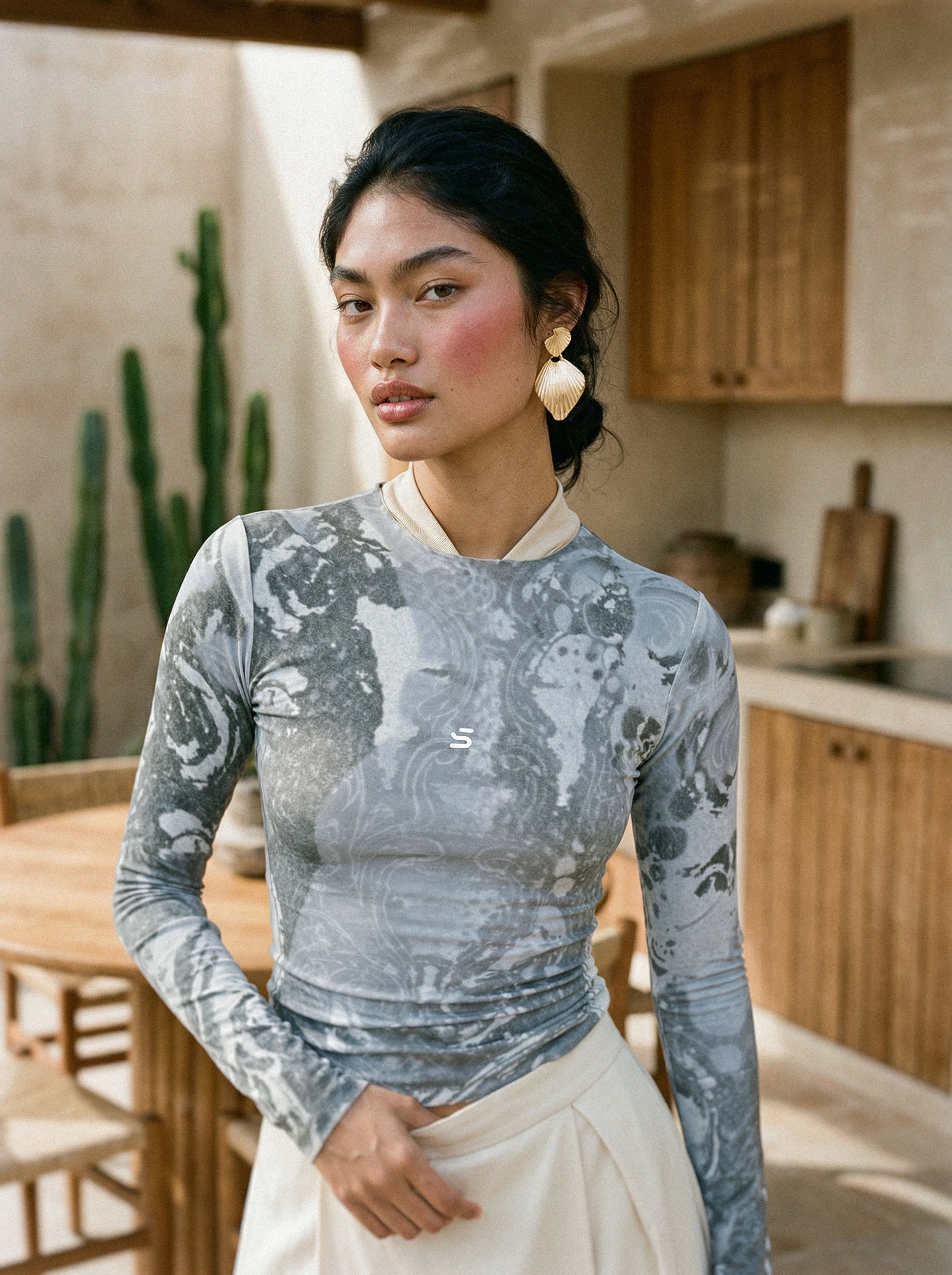 Woman wearing a patterned top in a kitchen setting