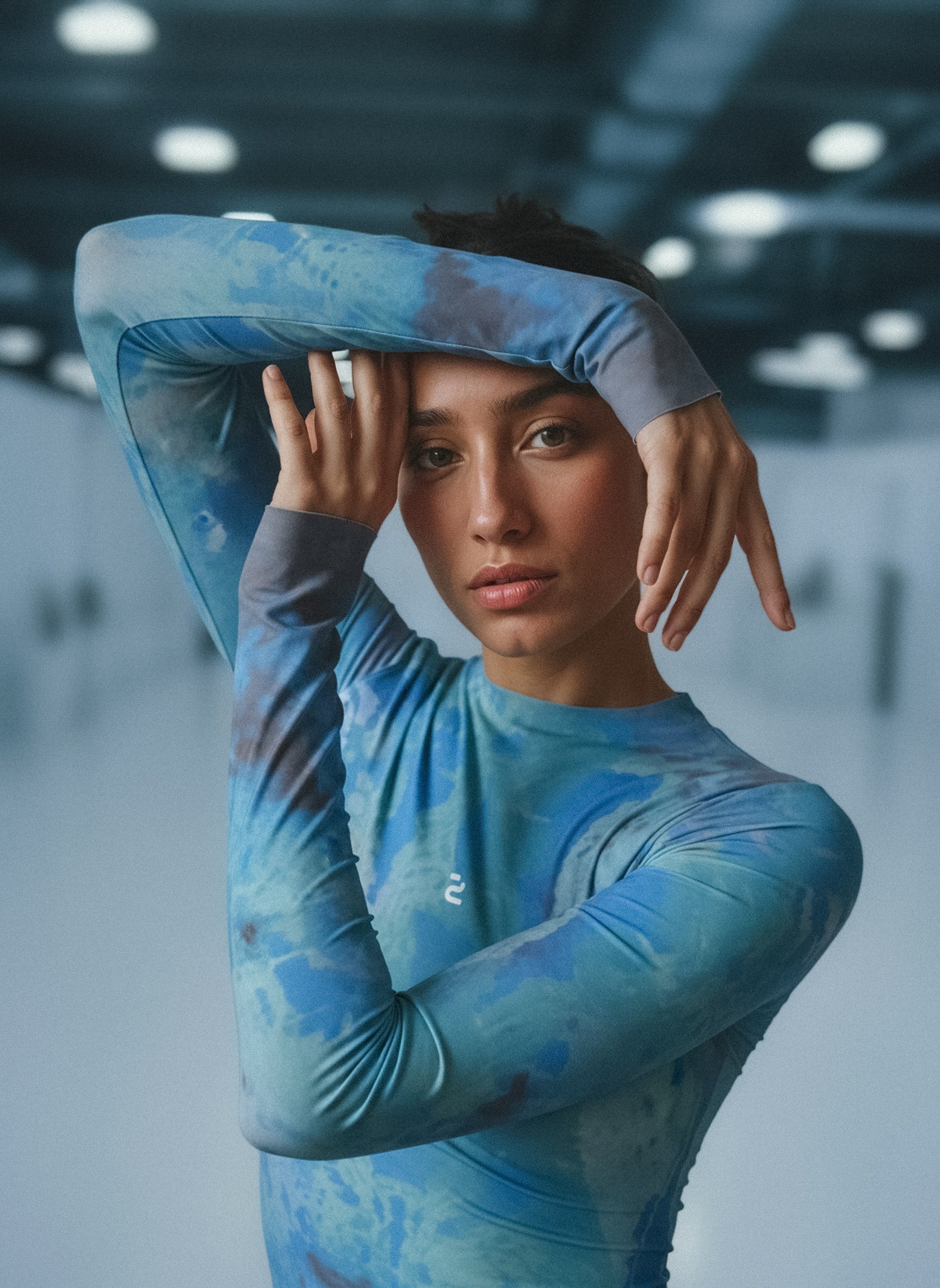Person wearing a blue patterned second-skin longsleeve in an indoor setting
