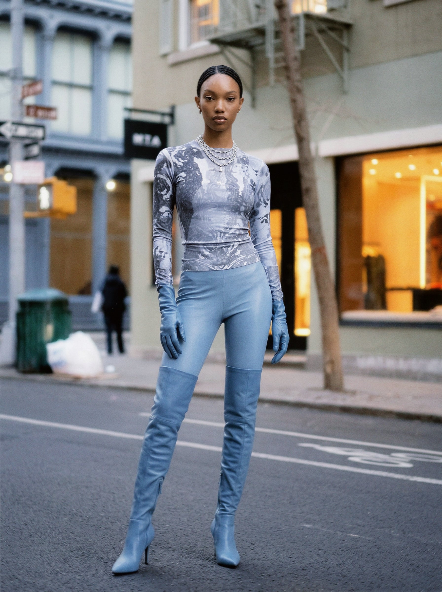 Woman in futuristic grey art longsleeve top outfit standing on a city street