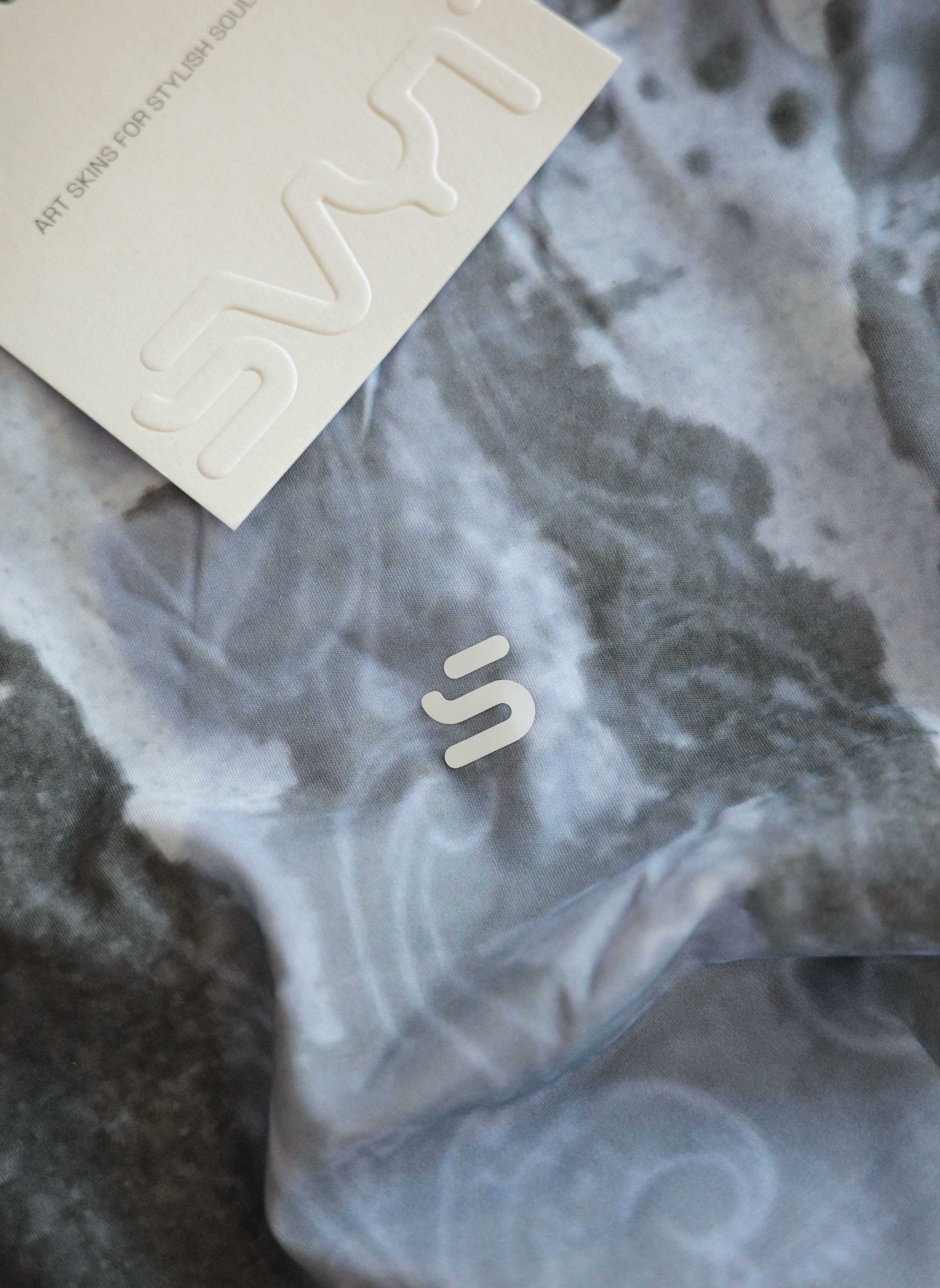 Marbled gray and white fabric with a brand logo on top