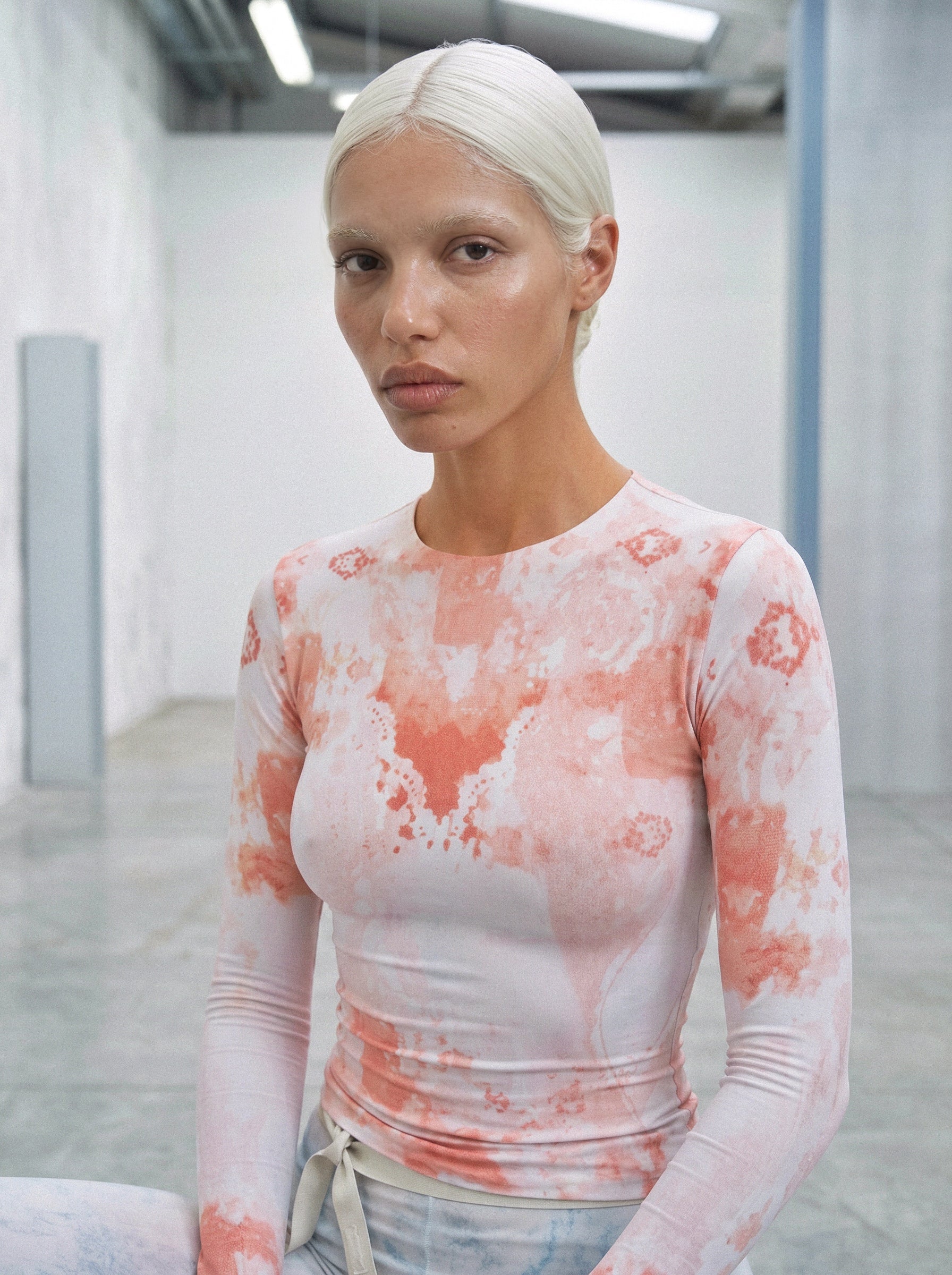 Person wearing a long-sleeve top with a floral pattern in an indoor setting