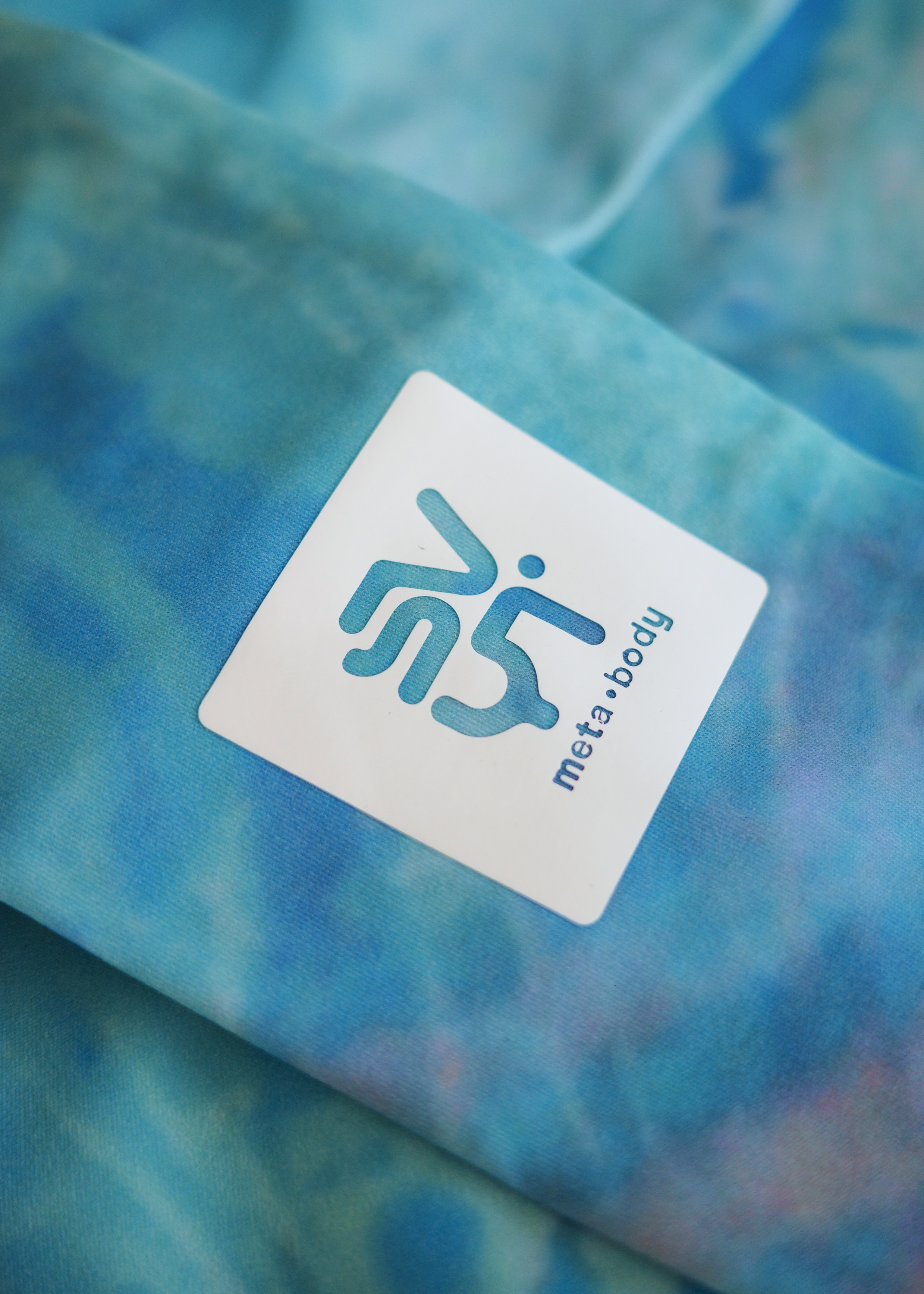 Close-up of a blue textured fabric with a 'meta body' label.